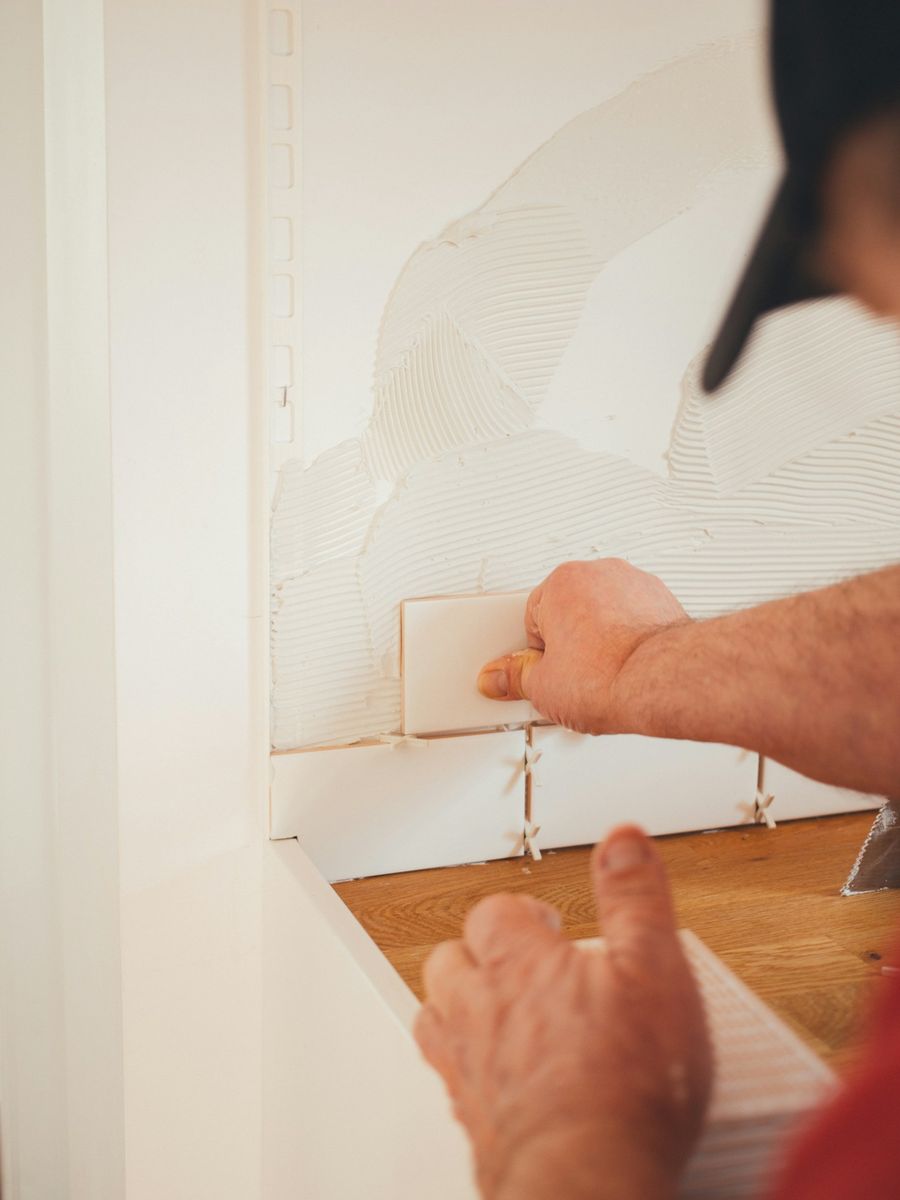 Colocación de azulejo blanco en una pared de baño